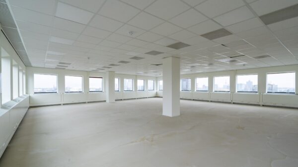 Leeg kantoorpand aan het Johanna Westerdijkplein met grote ramen en systeemplafond.